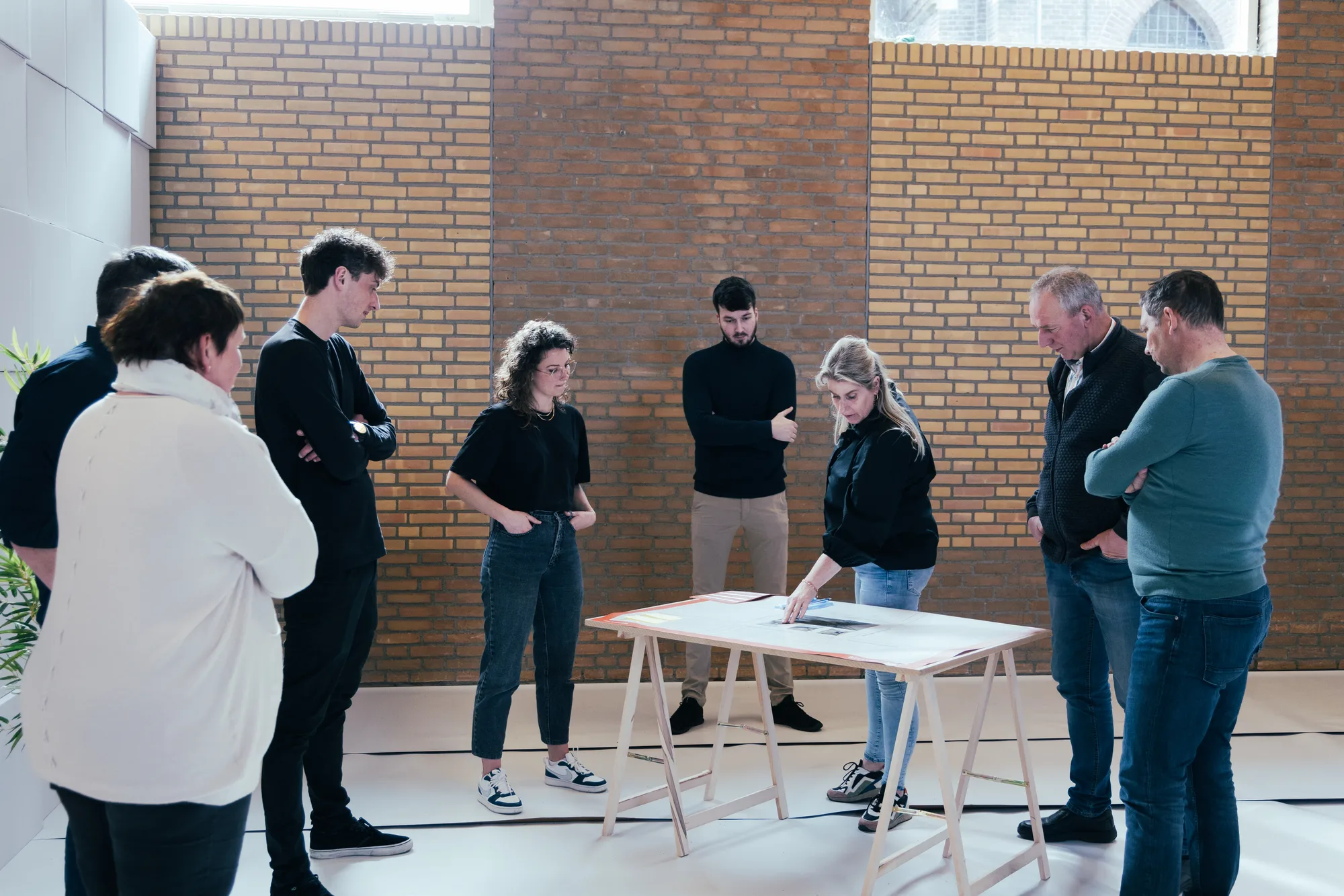 Bewoners van Nieuw-Vossemeer in gesprek rond een tafel tijdens het participatie-event in de gymzaal